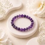 Natural Amethyst bracelet with 8 mm purple beads on a white stand