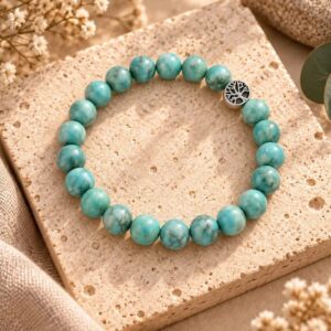 Natural Turquoise bracelet with tree of life charm on a stone tile