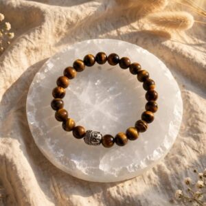 Natural Tiger's Eye bracelet with 8 mm golden brown beads and silver Buddha bead on a selenite plate